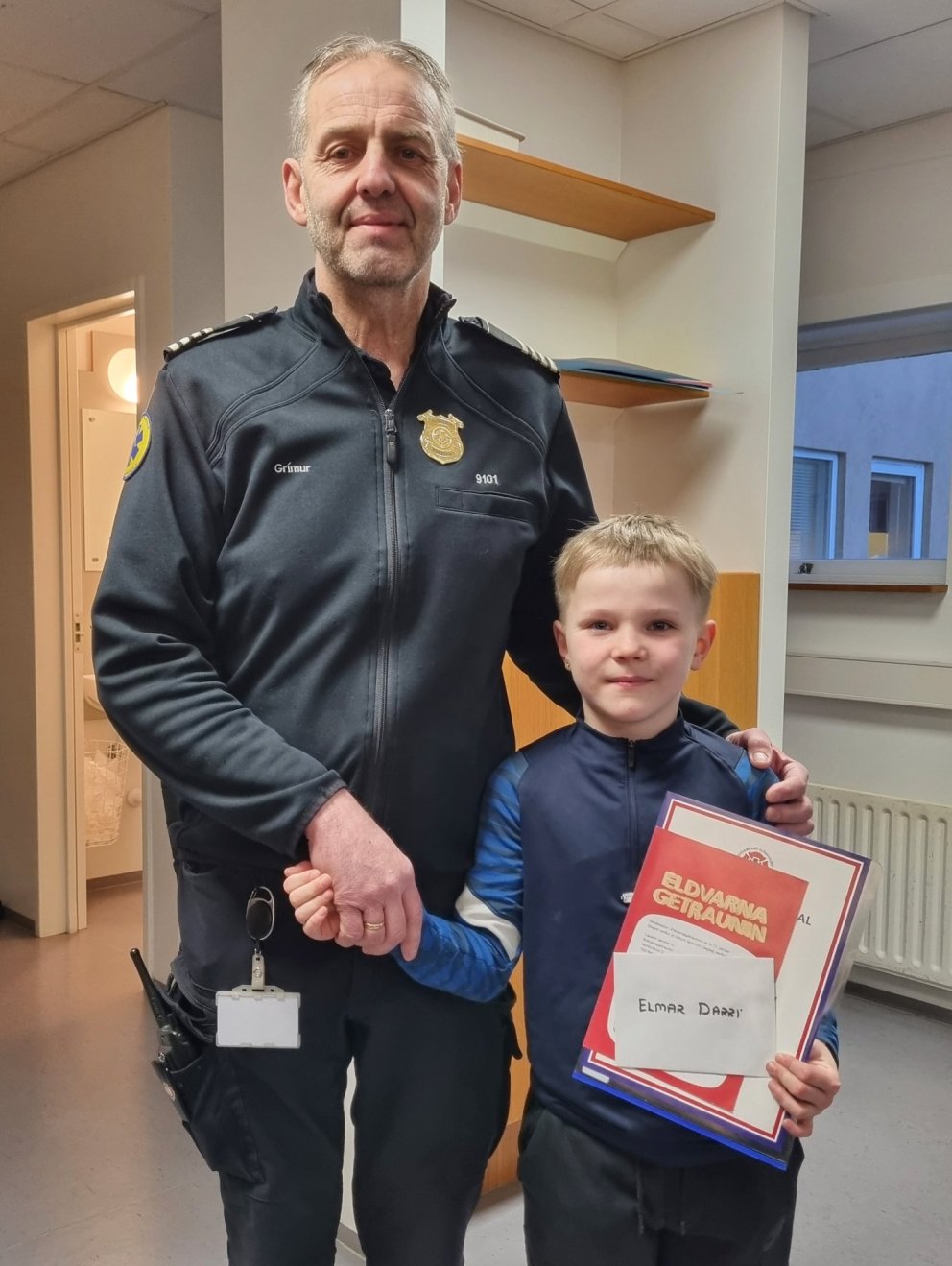 Grímur Kárason slökkviliðsstjóri afhendir Elmari Darra vinninginn.