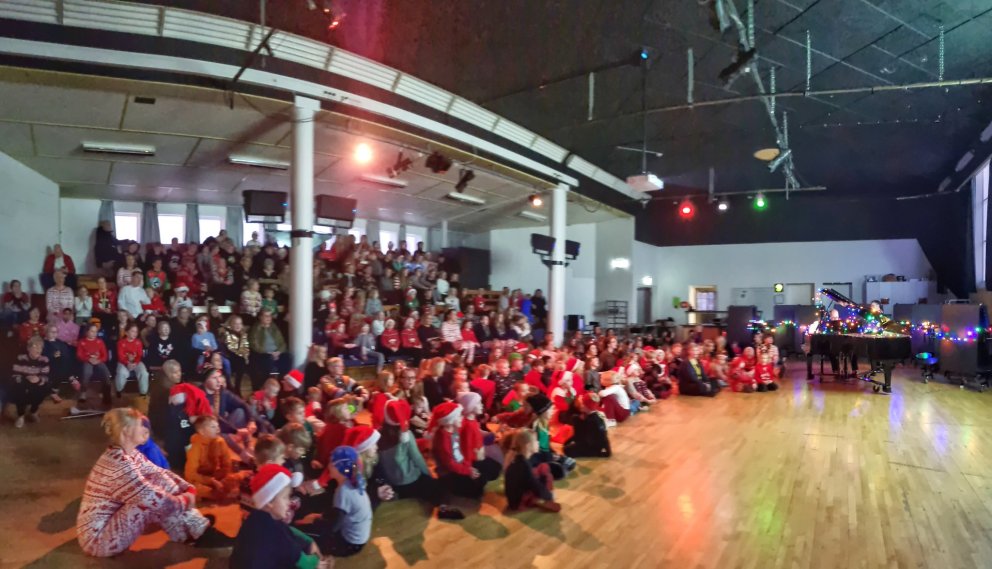 Fjölmenni í Sal skólans að syngja jólalögin.