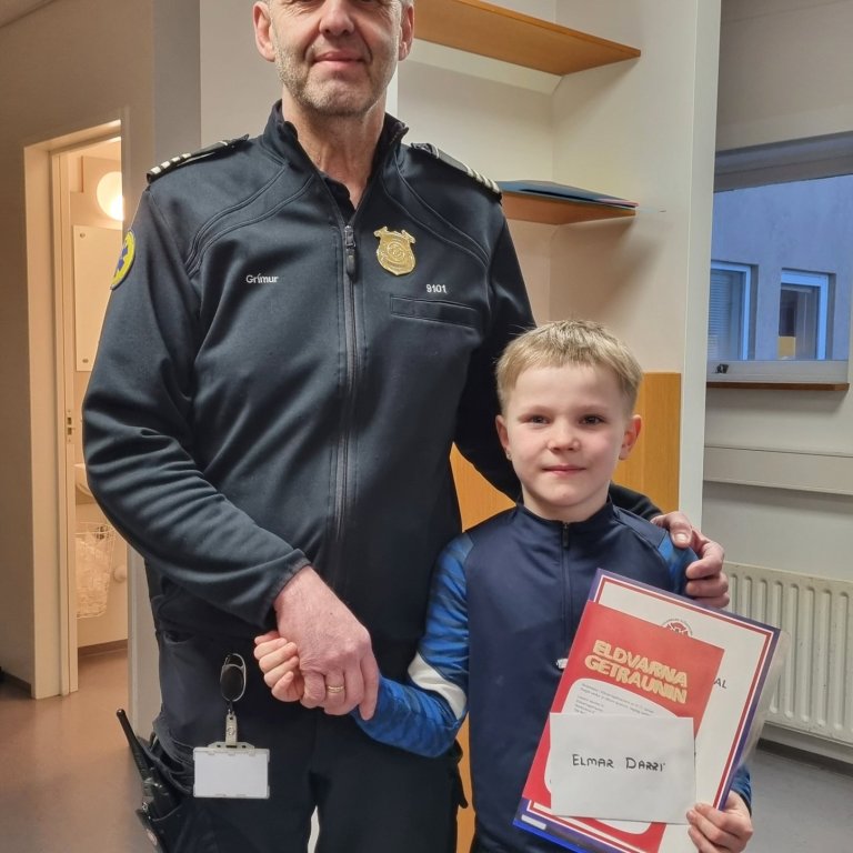 Grímur Kárason slökkviliðsstjóri afhendir Elmari Darra vinninginn.